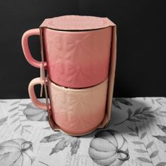 two pink mugs stacked on top of each other