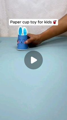 a person holding a cup with an easter bunny on it and the text paper cup toy for kids