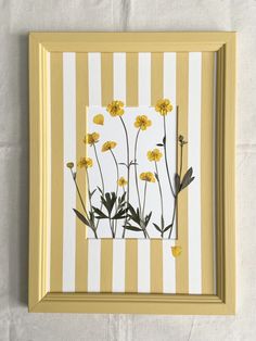 a yellow and white striped frame with flowers on it