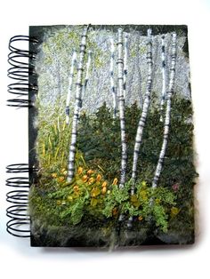 an altered photograph of trees and plants on a book with spiral pages in the middle