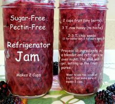 two jars of jam sitting on top of a table next to blackberries and raspberries