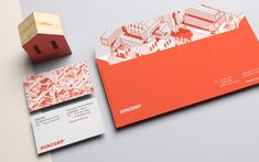 an orange and white business card next to a wooden block