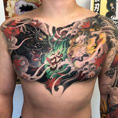 a man's chest covered in tattoos with dragon and flowers on the top half