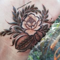 a woman's hand with a flower tattoo on it