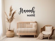 a baby's room with a crib, chair and wall decal that says hannah marie