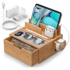 an apple watch, cell phone and other items in a wooden box with charging cords