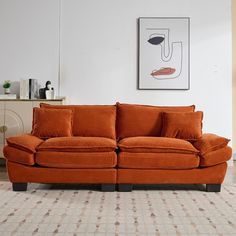 an orange couch sitting on top of a rug