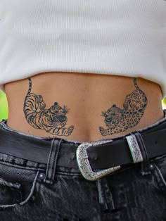 a woman's lower back with tattoos on her stomach and two tigers in the middle