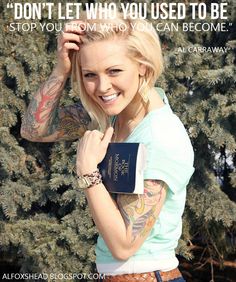 a woman holding a passport and smiling at the camera while standing in front of some trees