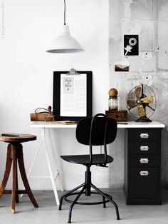 a desk with a chair, lamp and pictures on the wall