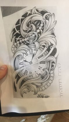 a person holding up a piece of paper with a drawing on it that has a clock in the middle