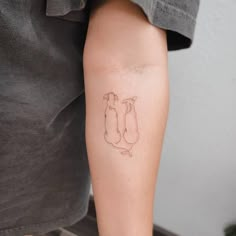 a person with a tattoo on their arm holding onto a leg that has two cats in it