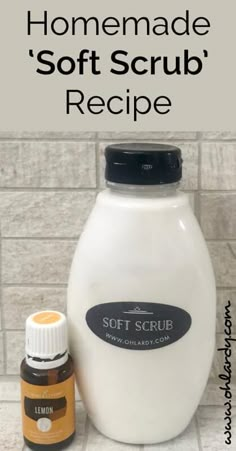 a bottle of soft scrub next to an essential oil