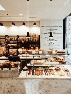 a bakery filled with lots of different types of breads and pastries on display