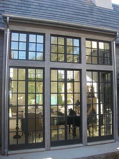 an open patio door with glass panes on the front and side of it, in front of a house