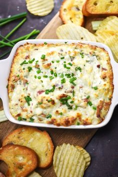 a casserole dish with cheese, green onions and crackers on the side