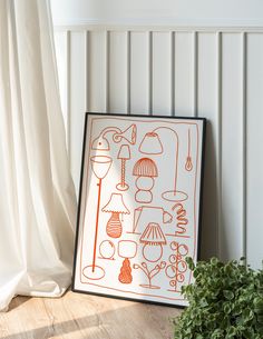 an orange and white art piece sitting on top of a wooden floor next to a potted plant