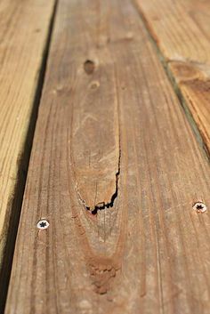 a close up of some wood planks with holes in the middle and one missing