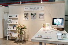 a white table with flowers and pictures on it in front of a wall mounted computer