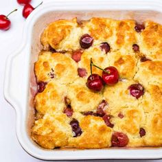 a casserole dish with cherry toppings and fresh cherries on the side