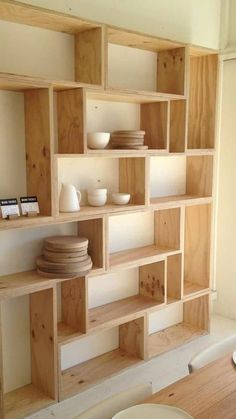 the shelves are made out of wood and have bowls on them, plates in front of them