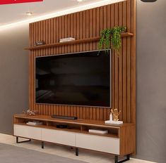 a living room with a large television mounted on the wall and wooden paneling around it