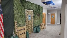 an office hallway with boxes and bags on the floor next to a wall covered in moss