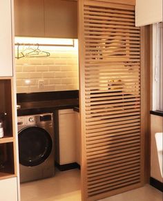 a washer and dryer in a room with wooden slats on the door