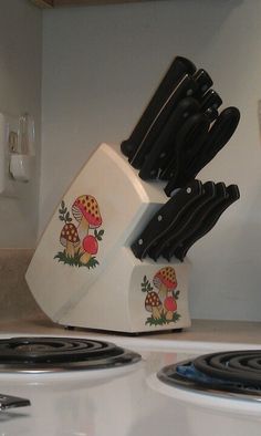 a bunch of knives are stacked on top of each other in front of the stove