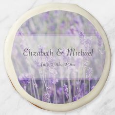 a wedding cake with lavender flowers on it and the words elizabeth & michael written in white