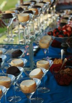 there are many desserts on the table with wine glasses in front of them, including cookies and ice cream