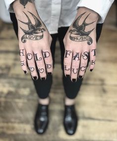 a person with tattoos on their hands is holding his hand up to show the words hold fast and love