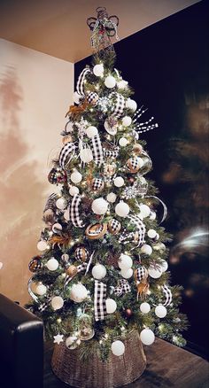 a decorated christmas tree in a basket with black and white ornaments on it's top