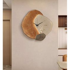 a clock that is on the side of a wall in a room with a table and chairs