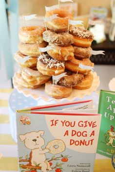 a stack of donuts sitting on top of a table next to two children's books