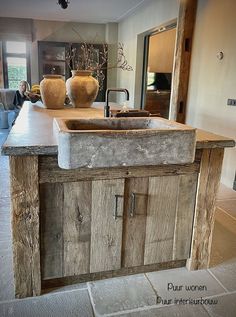 a rustic kitchen with an old sink and wooden cabinetry in the center, along with vases on the counter