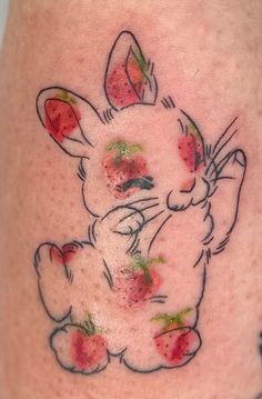 a small bunny with strawberries on it's leg and the outline of an animal