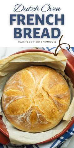 a loaf of bread sitting in a red bowl on top of a blue and white towel