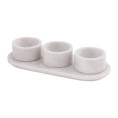 three white cups are sitting on a tray