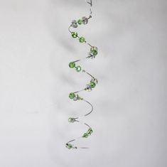 a string of green glass beads hanging from a ceiling