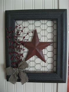 a red star is hanging on the wall next to a black frame with a bow