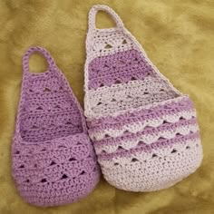 two crocheted purses sitting on top of a bed