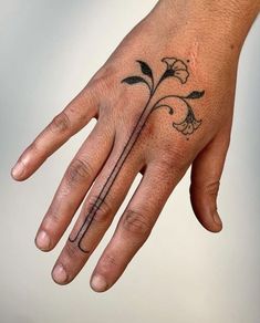 a person's hand with a flower tattoo on it