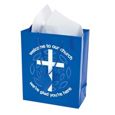 a blue paper bag with a cross and the words, welcome to our church we're glad you're here