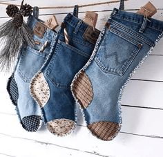 two pairs of jeans hanging from a clothes line with pine cones in the back pocket