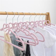 several clothes hangers are hanging on a wooden rail