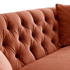 a brown couch with two pillows on it's back and the seat upholstered