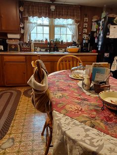 a kitchen with a table and chairs covered in a blanket next to a sink area