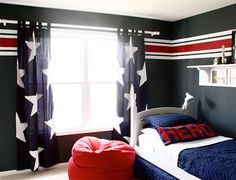 a bedroom decorated in red, white and blue