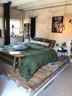 a large bed sitting on top of a wooden pallet in a bedroom next to a window